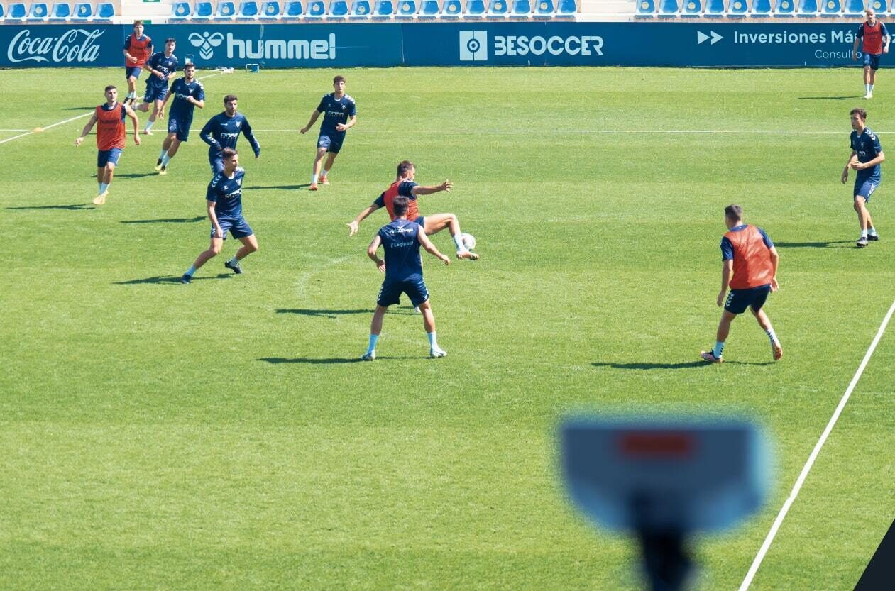 A football team playing a game on the pitch with a Focus Flex camera in the foreground
